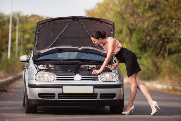 USAA MBI mechanical breakdown insurance woman checking car under the hood car on the road